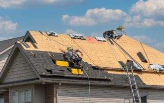 Roofers completely replace old asphalt shingle roof during summer